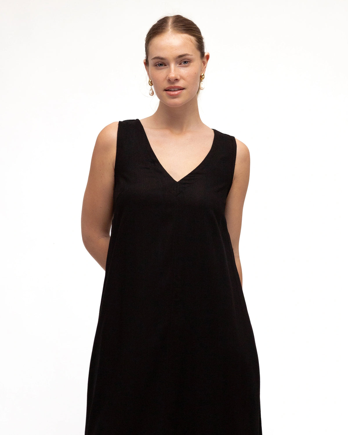 Woman wearing a black sleeveless dress on a white background